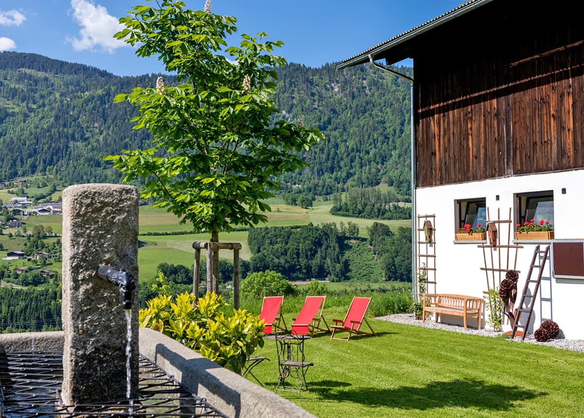 Liegewiese  mit Liegestühlen neben dem Stall