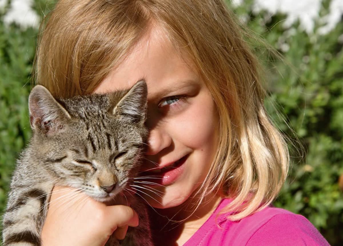 Mädchen spielt mit Katze